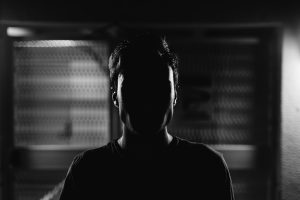 A man with his face in shadow.